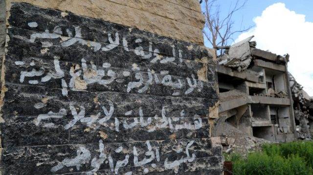 Natpis "Islamske države" na zidu uništene zgrade u Raqqi. Foto: EPA-EFE/AHMED MARDNLI